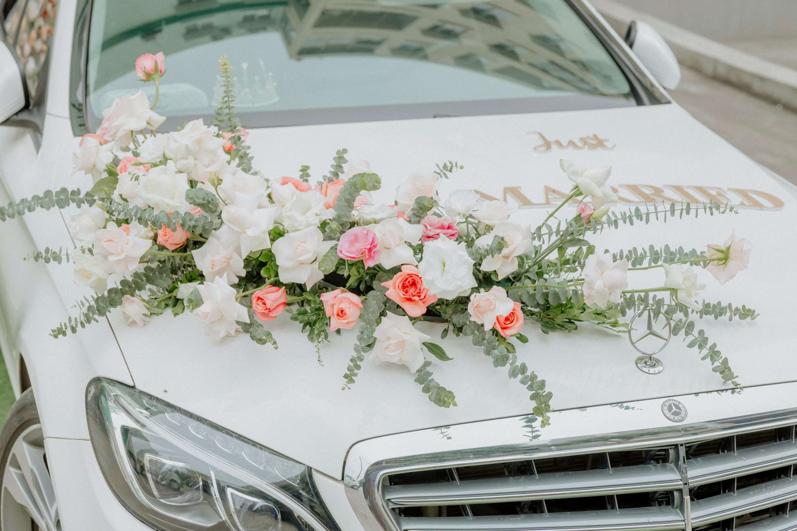 Close-up of a wedding car adorned with beautiful flower arrangements.